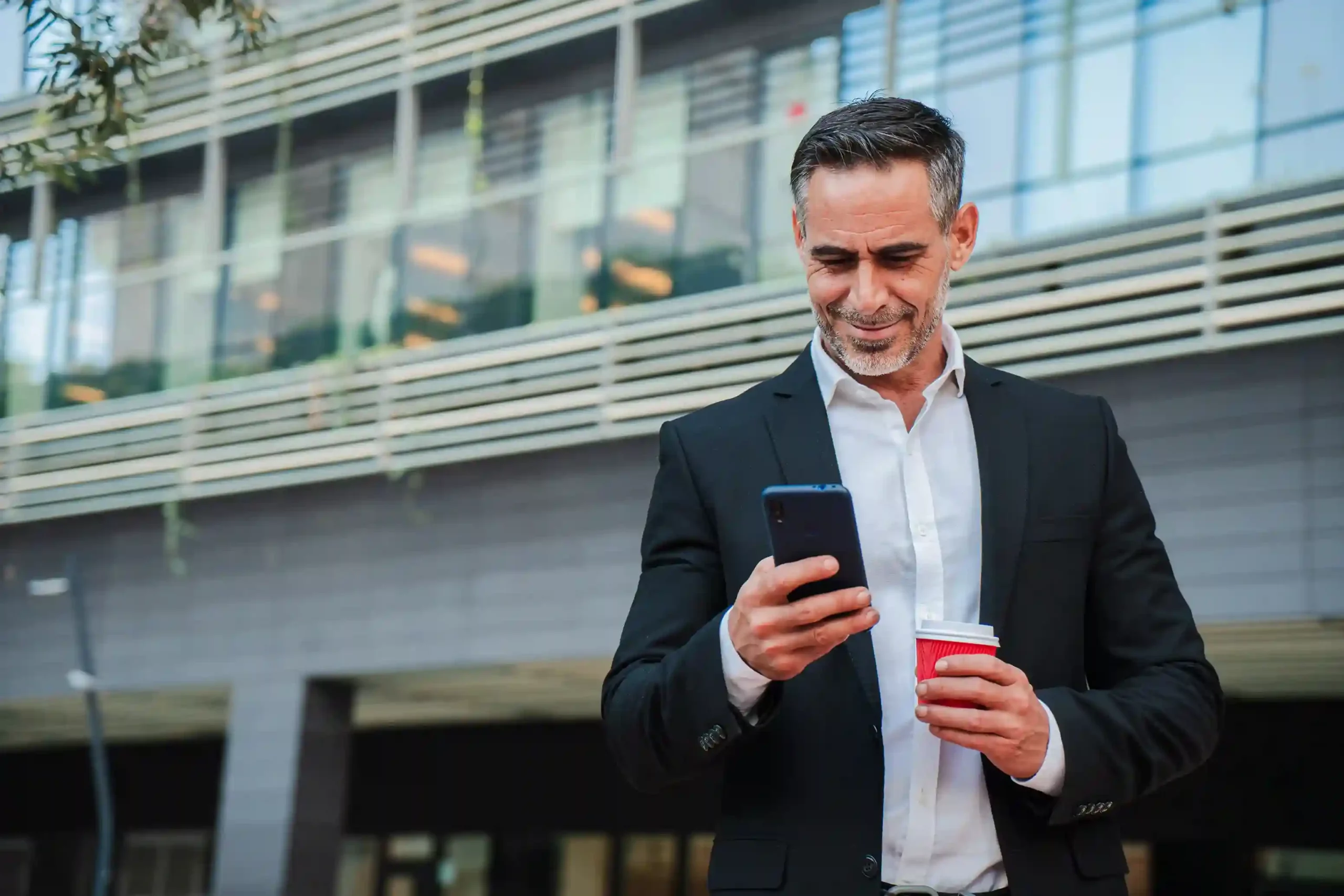 A user confidently monitoring segmented outreach results on a mobile device while managing targeted campaigns. A business professional reviewing targeted message delivery to specific audience segments on his smartphone.