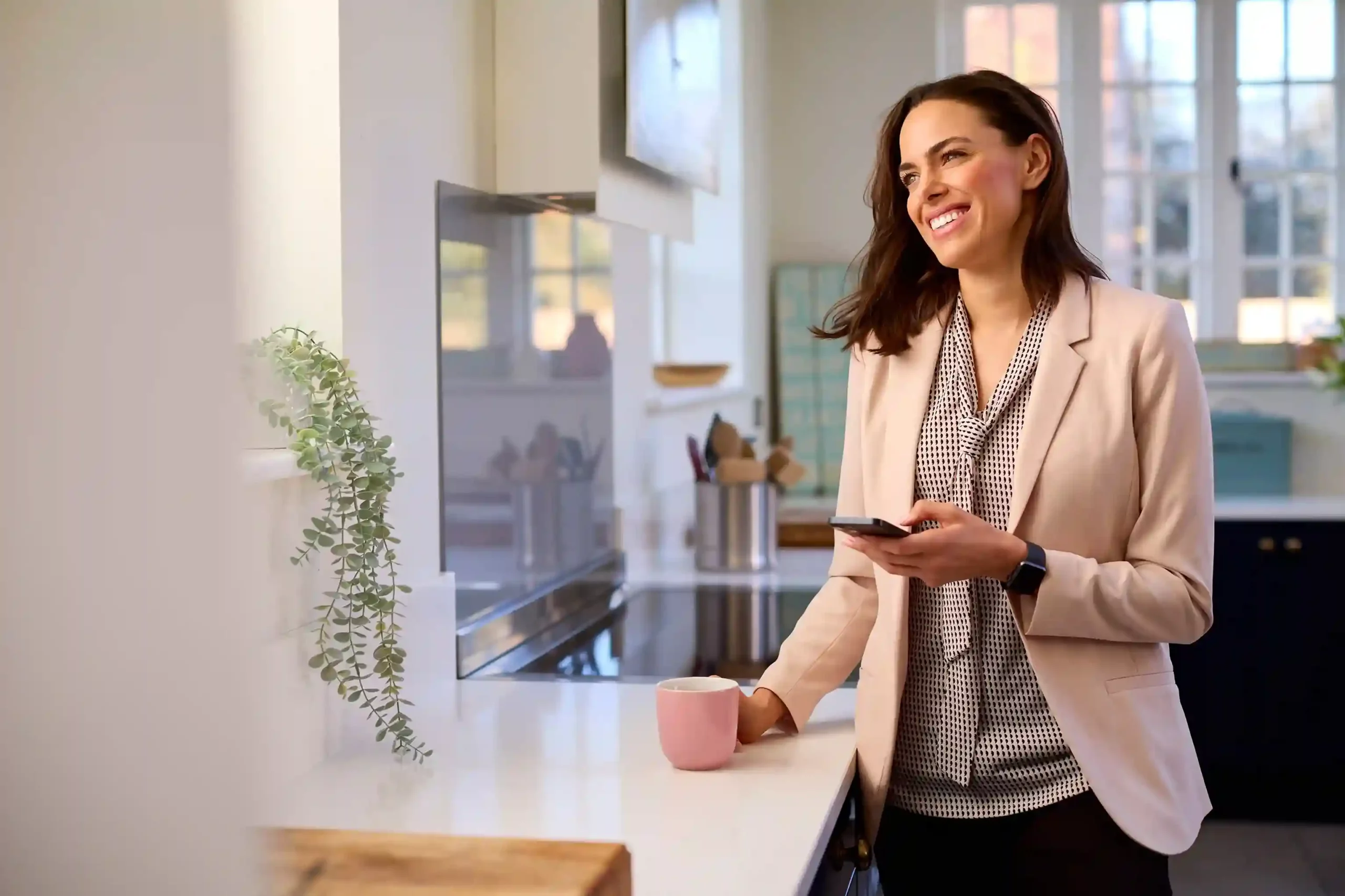 A business professional checks updates on her mobile phone, confidently staying connected with customers while Indosoft manages number porting behind the scenes without service interruption. A professional smiles while checking her phone in a calm workspace, continuing to receive calls and messages seamlessly as her business number is ported to Indosoft without disruption.