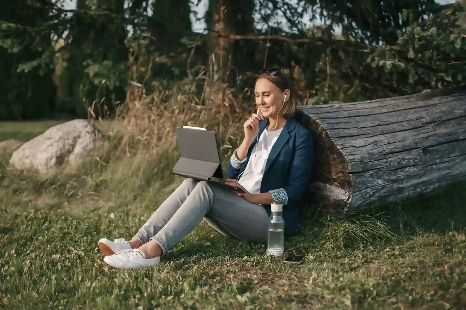 A woman listens attentively through earphones while interacting with a device, illustrating how IVR menus help callers move step by step to the right destination. A professional sits outdoors with a tablet and headset, calmly listening and making a selection, reflecting how IVR guides callers through menu options to reach the right support without assistance.