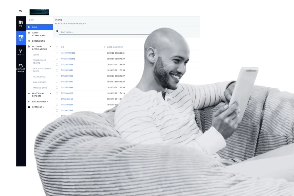 Satisfied customer using a tablet while a Q-Suite contact center dashboard displays routed DID numbers, illustrating how tracking performance metrics improves the customer experience.