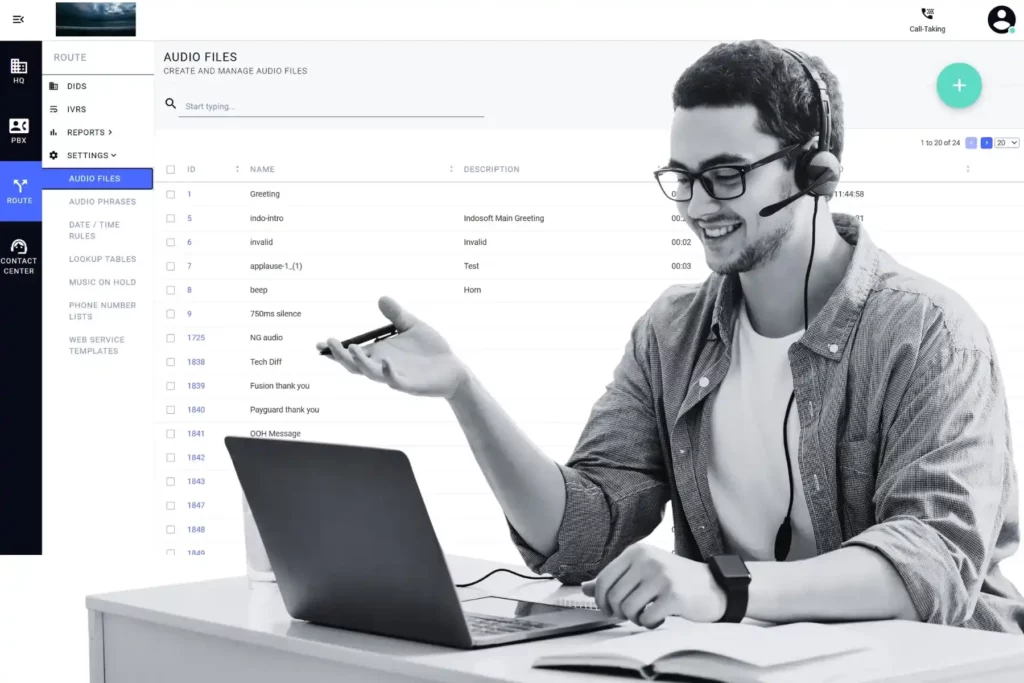 A contact center agent wearing a headset smiling at his laptop while managing audio files in the Q-Suite NG routing interface.